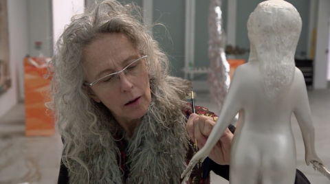 Still of the artist Kiki Smith working on a sculpture. Taken from a documentary by Claudia Müller called Kiki Smith: Work made in 2015.
