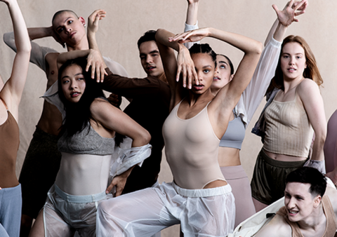The Rambert2 company dancers dressed in neutral coloured clothes striking a pose