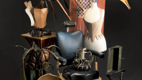 Against a black background, a selection of artefacts arranged in a tableau. 