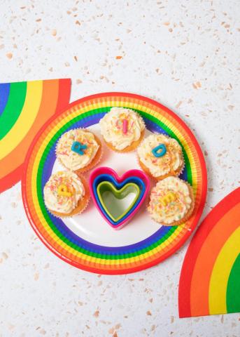Image of a rainbow-coloured plate with multi colour cupcakes on it